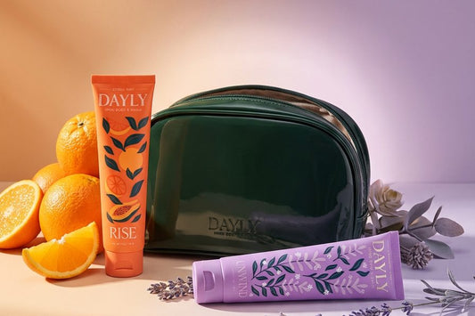 DAYLY Rise and Unwind toothpaste with a green travel bag, fresh oranges and lavender