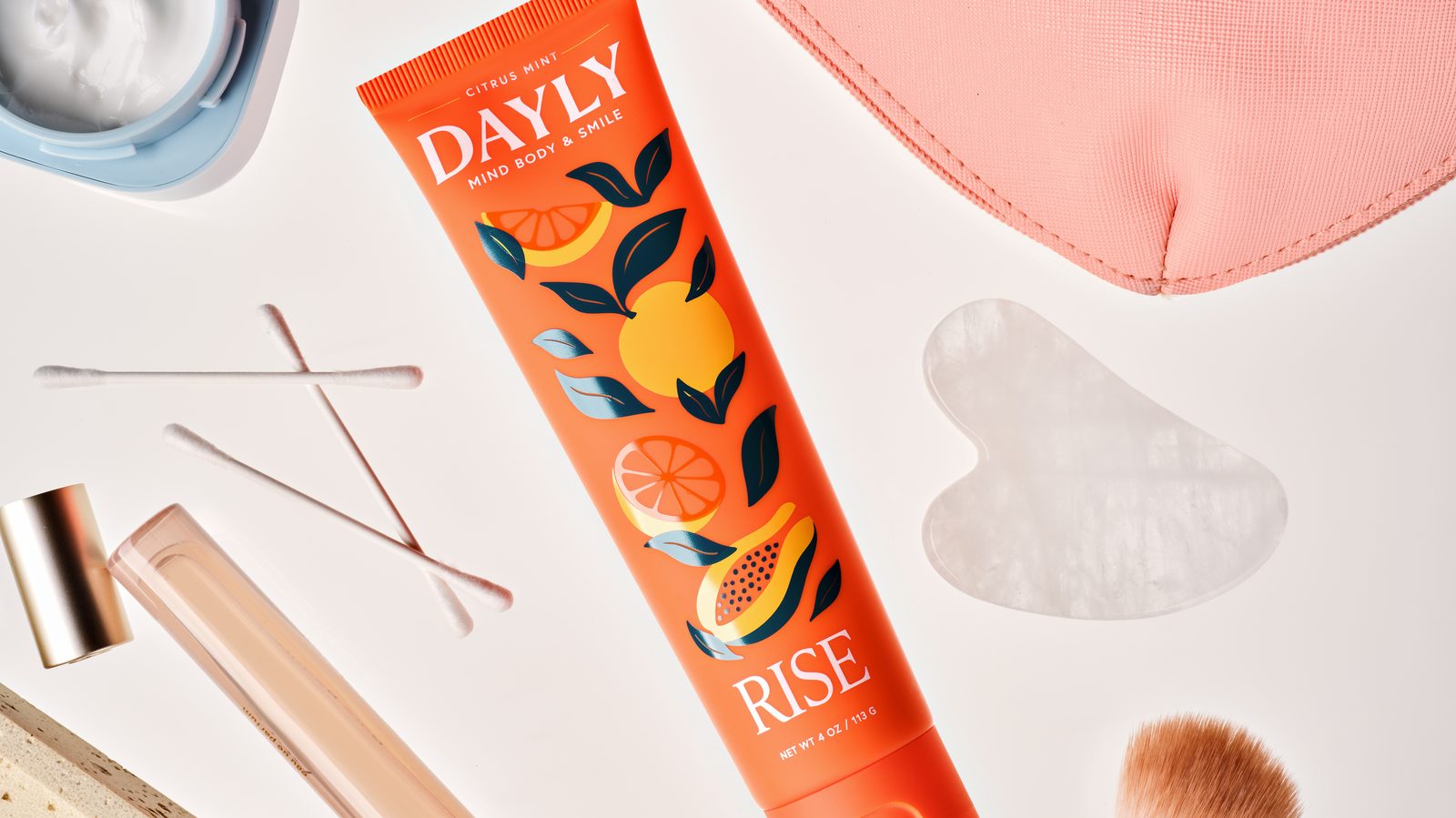 DAYLY Rise toothpaste in a flat lay with skincare tools