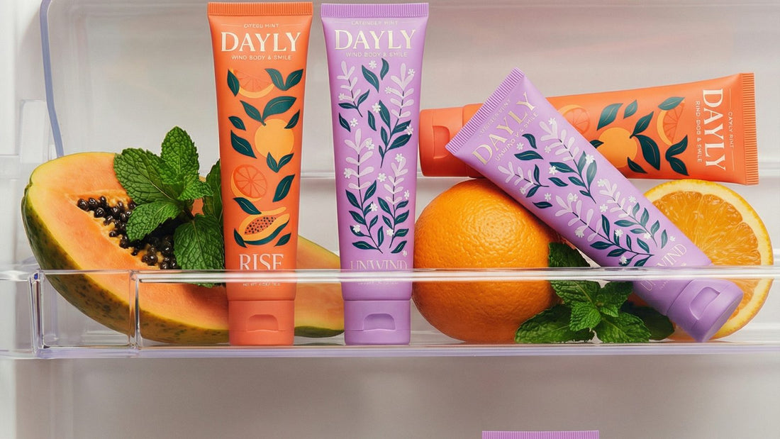 DAYLY toothpaste tubes on a fridge shelf with papaya and oranges