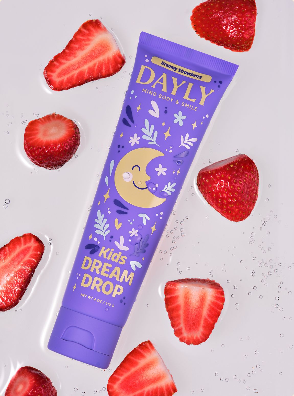 DAYLY DREAM DROP kids toothpaste surrounded by sliced strawberries