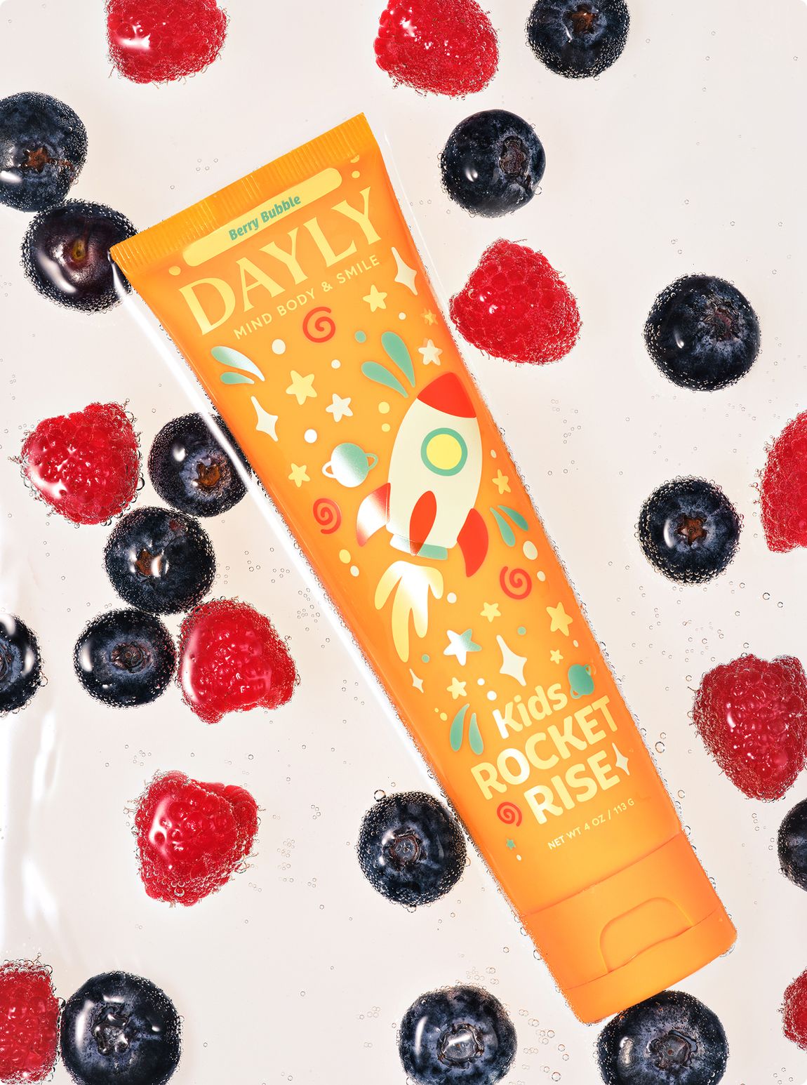 DAYLY ROCKET RISE kids toothpaste surrounded by raspberries and blueberries