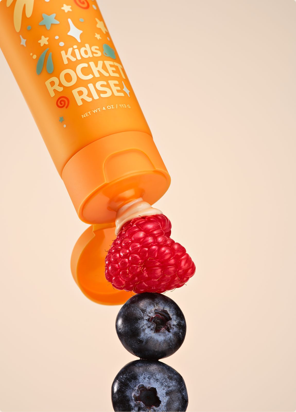DAYLY ROCKET RISE tube with a raspberry and blueberries stacked on the cap