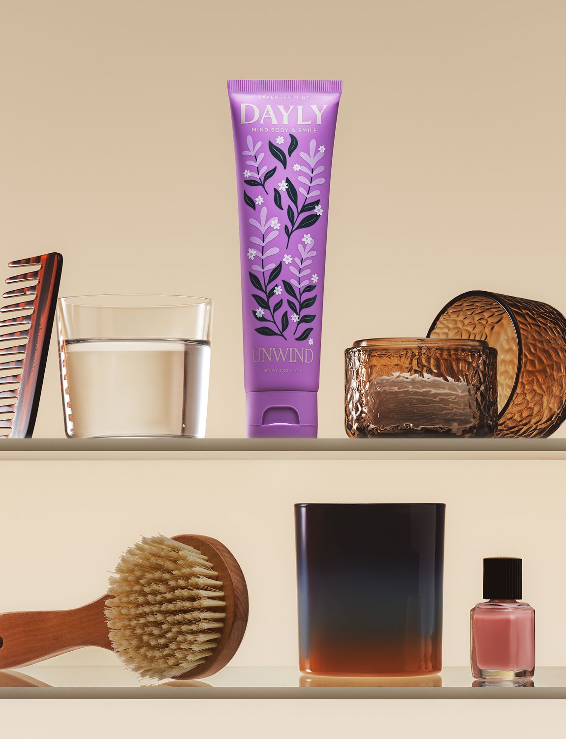 DAYLY UNWIND toothpaste on a bathroom shelf with a glass, comb and candle